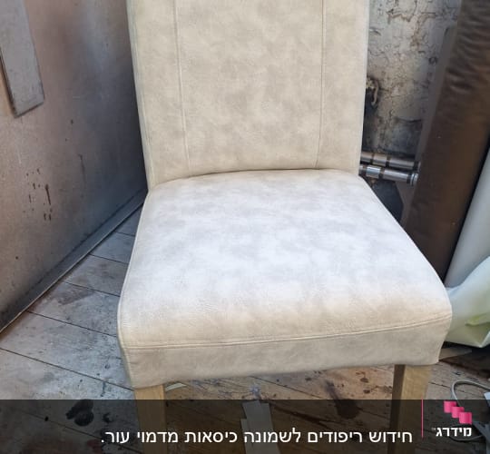 כיסא מרופד בצבע בהיר על רצפת עץ בסדנה